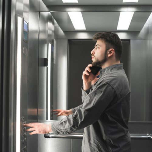 businessman-is-phone-elevator-pressing-button-2
